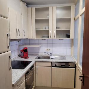 施特勞賓的住宿－Ludwigsturm Appartement in Straubing，厨房配有白色橱柜和红色用具