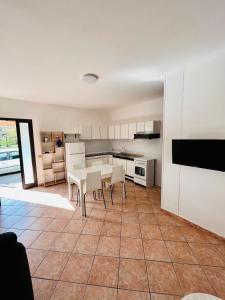 a kitchen and dining room with a table and chairs at CANNONHOUSE La Pavoncella Rosa in Bari Sardo