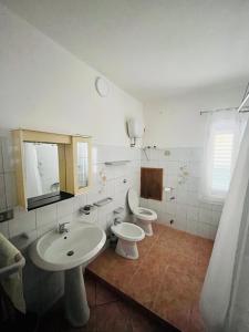 uma casa de banho com 2 lavatórios e 2 WC em CANNONHOUSE La Pavoncella Rosa em Bari Sardo