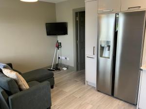 a living room with a couch and a refrigerator at Small,smart,tidy 2 bed apartment in Galway