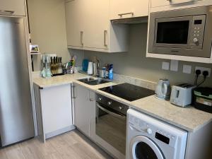 a kitchen with a stove top oven next to a dishwasher at Small,smart,tidy 2 bed apartment in Galway