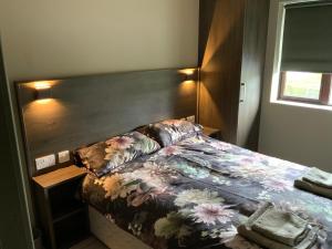 a bedroom with a bed with a wooden headboard at Small,smart,tidy 2 bed apartment in Galway