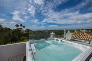 a hot tub on the balcony of a house at Vale Do Lobo Resort in Vale do Lobo