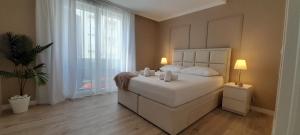 a bedroom with a white bed and a large window at Maboka Studio in Zadar