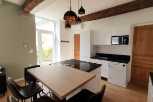 a kitchen with a table and chairs in a room at Classé 4 étoiles - Cybèle - Centre ville 2 Chambres, cour privative et Garage in Vienne