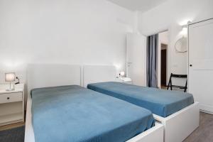 a white bedroom with two beds and a mirror at Moneglia Mare in Moneglia +27 photos