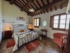 een slaapkamer met een bed, een stoel en ramen bij B&B Madonna Del Latte in Cannara