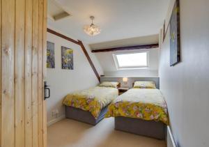 a bedroom with two beds and a window at Caer Mynach Cottage in Maesmynis