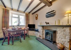 a living room with a table and a fireplace at Dee Mount in Carrog