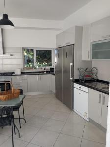 a kitchen with white cabinets and a stainless steel refrigerator at Monte Papa Figos in Malhão