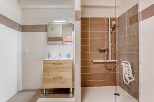 een badkamer met een douche en een wastafel bij OVELIA Villeneuve-Loubet - Les Vagues de Vaugrenier in Villeneuve-Loubet