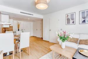 a living room with a white couch and a table at OVELIA Villeneuve-Loubet - Les Vagues de Vaugrenier in Villeneuve-Loubet