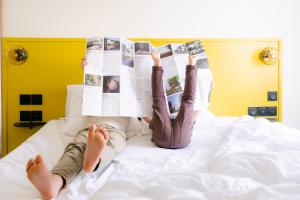 una persona sdraiata su un letto che legge un giornale di Le Lieu Dit a Nantes