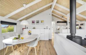 Nice Home In Harbore With Wifi في هاربور: مطبخ وغرفة طعام مع طاولة وكراسي بيضاء