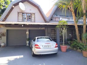 een witte auto geparkeerd voor een huis bij ADS Overnight Accommodation in Richards Bay