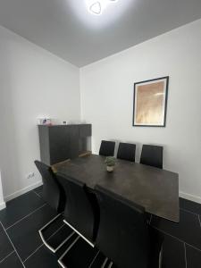a dining room with a black table and chairs at Cozy Aparthotel - Central City Suceava in Suceava