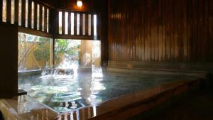 una piscina de agua en una habitación con una fuente en Fujiya en Kaga