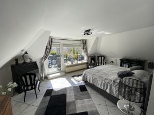 a bedroom with a bed and a large window at Maison Beaumont in Springe