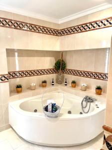 baño con bañera blanca y plantas en Magellan House, en Vilamoura