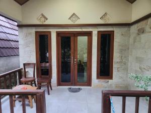 een patio met glazen deuren en stoelen op een veranda bij Run Gilis in Gili Meno