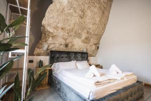 a bed in a room with a rock wall at La Cantinota - Locanda De Manincor Rooms in Arco