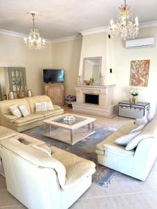 a living room with white furniture and a fireplace at Magellan House in Vilamoura
