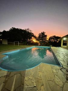 uma piscina à noite com agoal em Chácara com Piscina em Araçoiaba da Serra