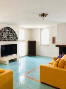 sala de estar con 2 sofás y TV de pantalla plana en Il Giardino di Elettra, en Palmadula