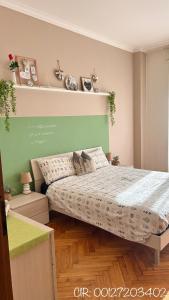 ein Schlafzimmer mit einem Bett und einer grünen Wand in der Unterkunft Trilocale Parco del Valentino in Turin