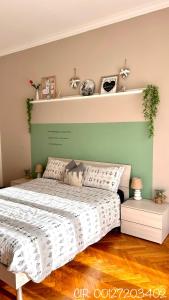 ein Schlafzimmer mit einem Bett mit einer grünen Wand in der Unterkunft Trilocale Parco del Valentino in Turin