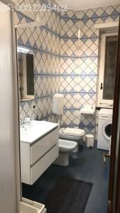 ein Badezimmer mit 2 WCs, einem Waschbecken und einem Spiegel in der Unterkunft Trilocale Parco del Valentino in Turin