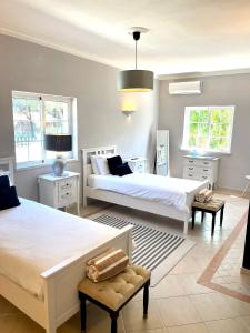 a bedroom with two beds and two chairs in it at Magellan House in Vilamoura