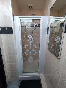 a shower with a glass door in a bathroom at Black Ocean Holiday Apartments in Blackpool