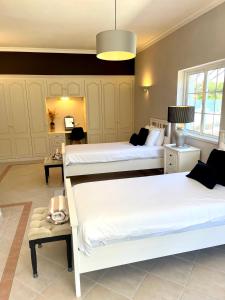 a bedroom with two beds and a table with a lamp at Magellan House in Vilamoura +75 photos
