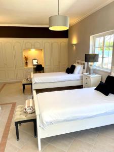 a bedroom with two beds and a table with a lamp at Magellan House in Vilamoura