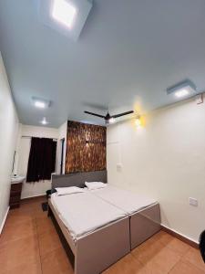1 dormitorio con 1 cama y ventilador de techo en Kvm Tourist Home, en Palakkad