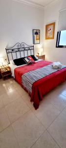 a bedroom with a large bed with a red blanket at ALMar We Go! Habitaciones privadas en Alcalá - Private Rooms - Pièces privées - Stanza privata in Alcalá