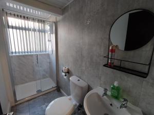 bagno con lavandino, servizi igienici e specchio di Black Ocean Holiday Apartments a Blackpool