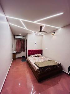 1 dormitorio con 1 cama y suelo rojo en Kvm Tourist Home, en Palakkad