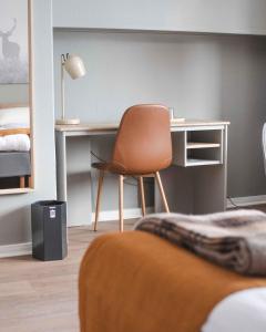 um quarto com uma secretária e uma cadeira ao lado de uma cama em Storlien Högfjällshotell AB em Storlien