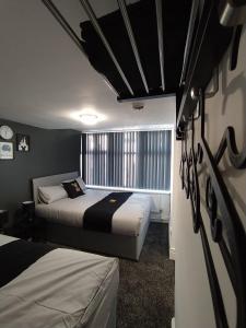 a bedroom with two beds and a window in it at Black Ocean Holiday Apartments in Blackpool