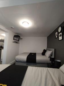 a bedroom with two beds and a clock on the wall at Black Ocean Holiday Apartments in Blackpool