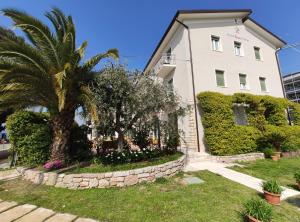 un bâtiment blanc avec un palmier en face dans l'établissement Hotel 2 Palme, à Torri del Benaco