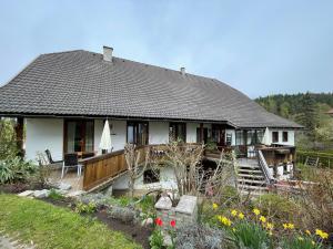a small white house with a porch and a yard at Apartments Wrolich in Latschach ober dem Faakersee