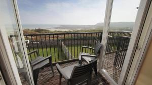 a balcony with chairs and a view of the ocean at Fennel Cottage in Port-Eynon