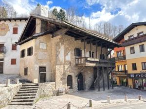 an old building with a balcony on the side of it at Chalet Francesca in Pieve di Cadore