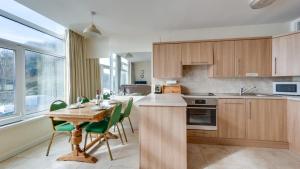 a kitchen with a wooden table and green chairs at Redcliffe Apartments E in Bishopston