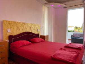 sypialnia z czerwonym łóżkiem i 2 czerwonymi poduszkami w obiekcie Apartments Oxa w Ulcinju