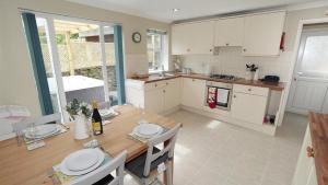 a kitchen with a wooden table and a dining room at Honeycomb Cottage in The Mumbles
