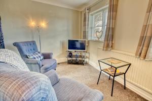 sala de estar con sofá y TV en Pass the Keys Cosy Hideaway in the Countryside, en Lincoln